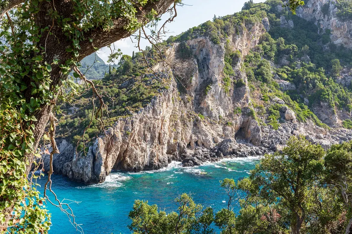 Steile groene kliffen en turquoise baai bij Paleokastritsa op Corfu