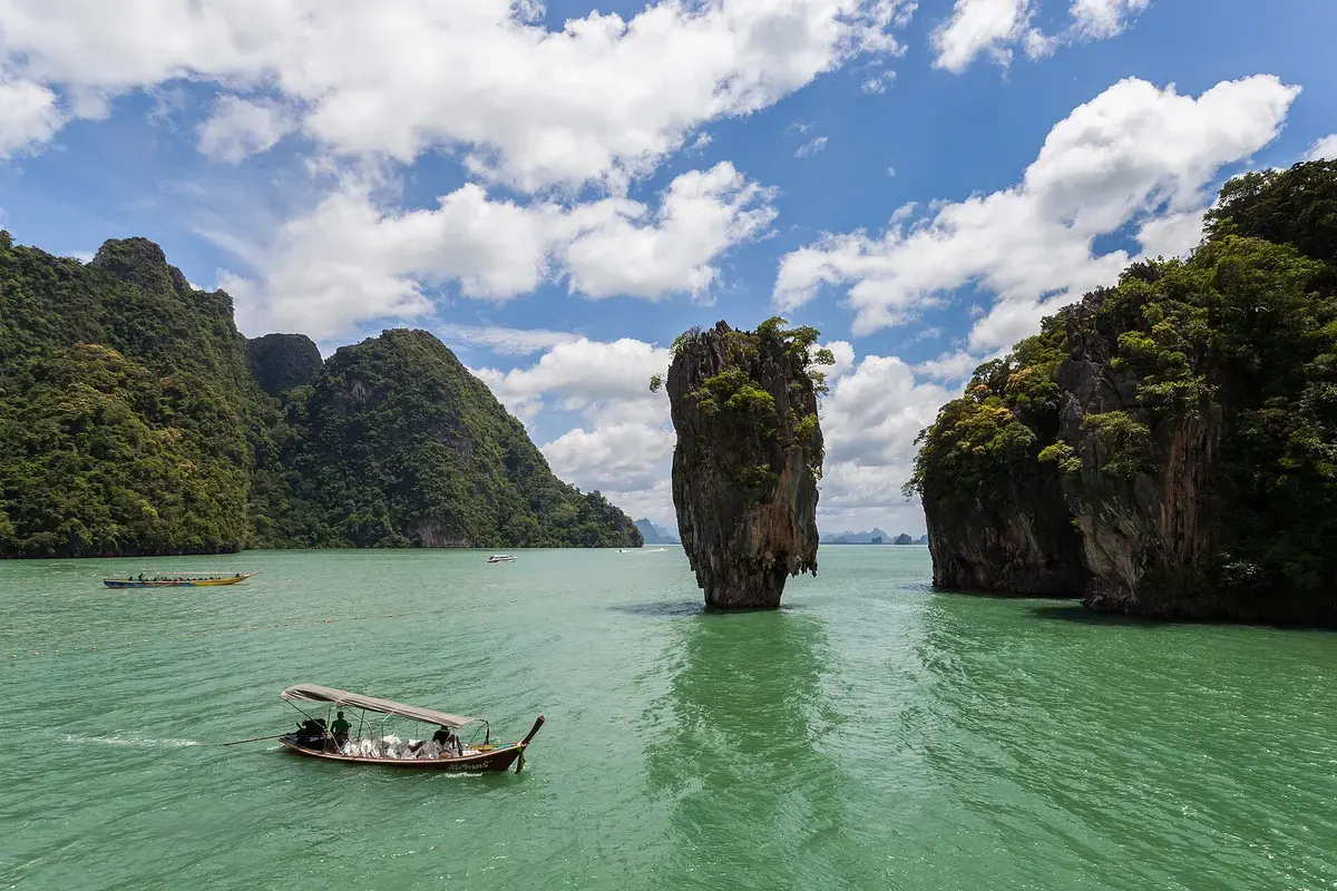 Kalkrots Ko Tapu in de groene baai van Phang Nga bij Phuket, met een longtailboot