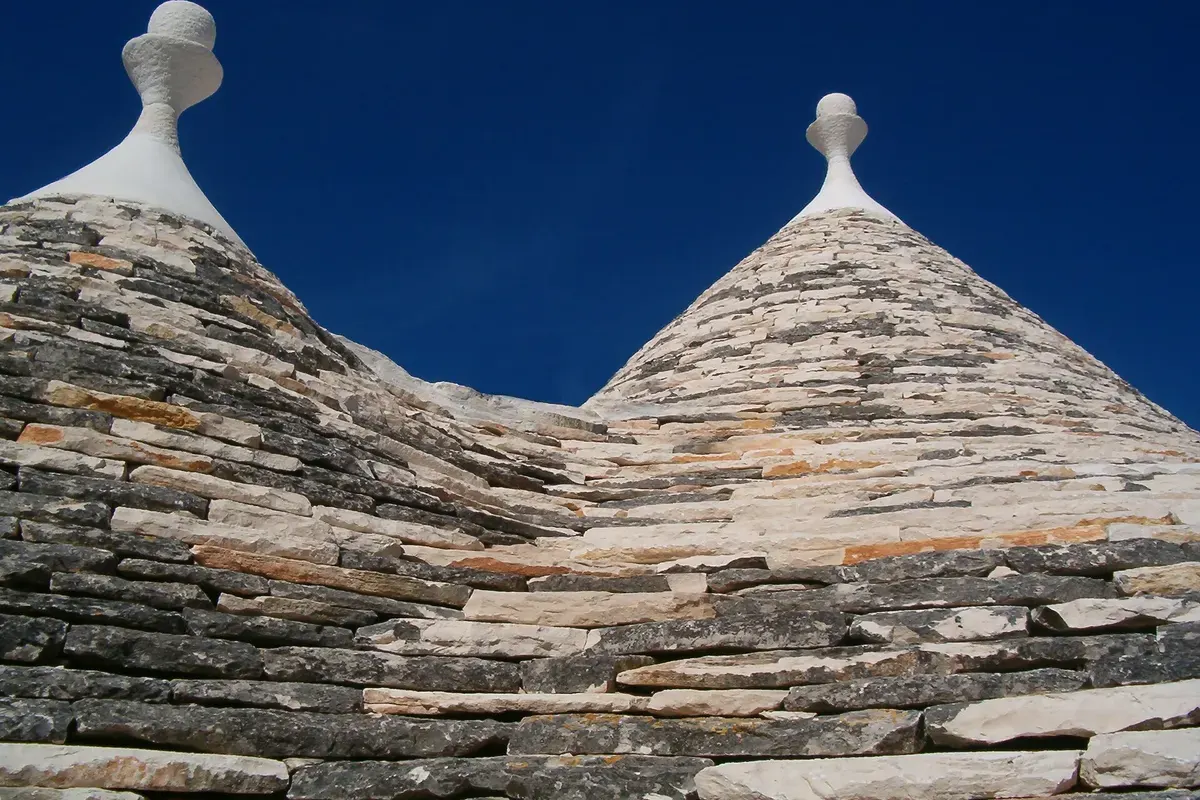 Kegelvormige stenen daken van trulli in Alberobello tegen een donkerblauwe lucht