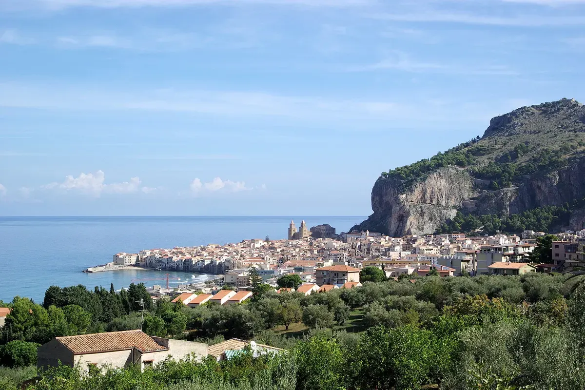De rokende Etna boven de daken van Catania, met besneeuwde top in het voorjaar