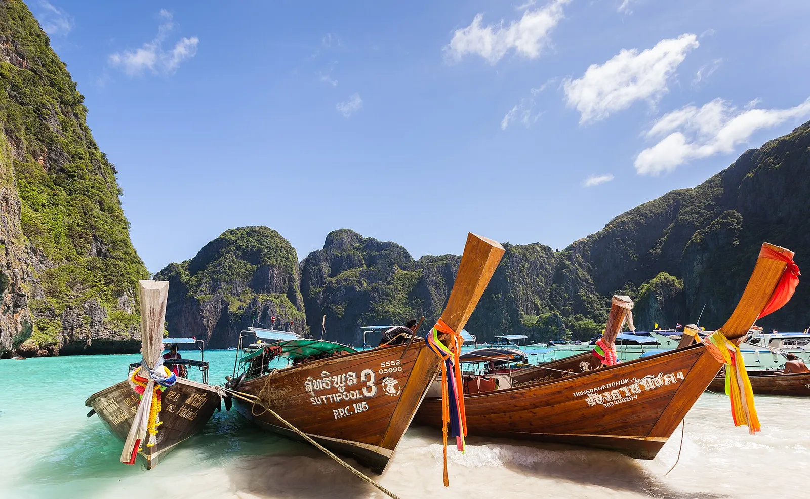 Longtailboten in de baai van Maya Bay tussen kalkstenen rotsen, Thailand
